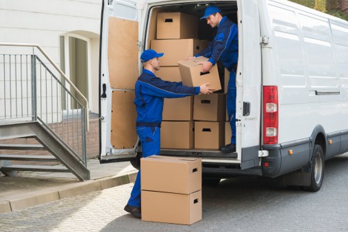 Packed moving boxes and furniture ready for transport in Brent
